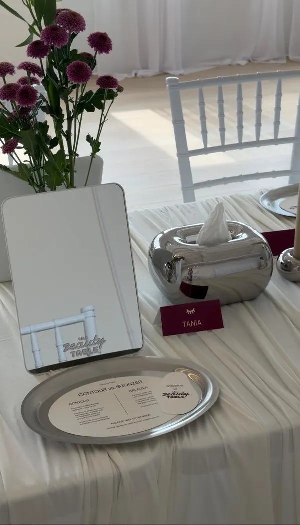 A place setting waiting for a guest: a tabletop mirror, a personalized name card, a welcome card and a printed contour vs. bronzer guide on a silver tray.